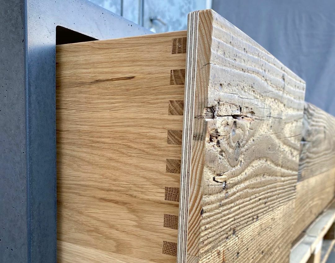 Gezinkte Schubladen mit Altholz-Front in Beton-Lowboard
