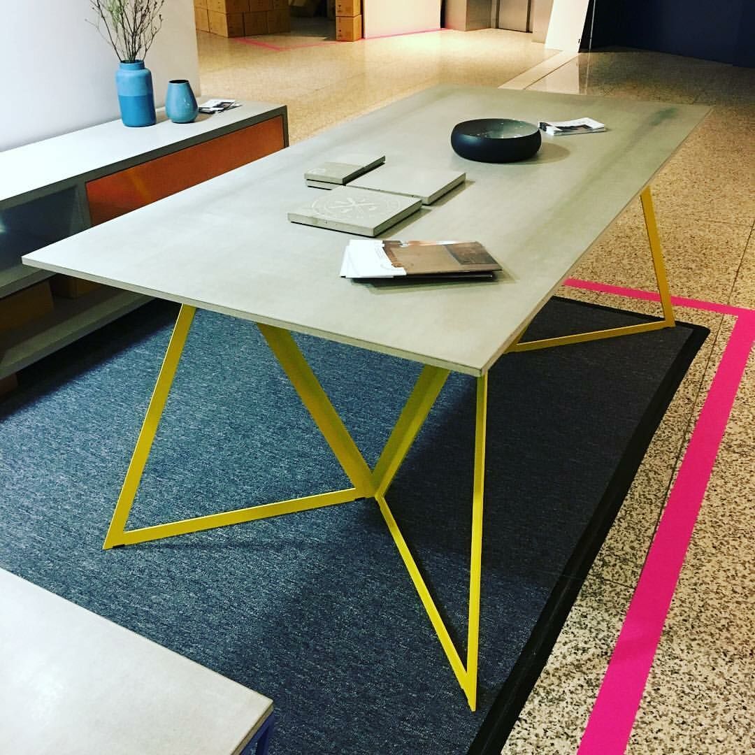 Betontisch mit gelben Stahlbeinen