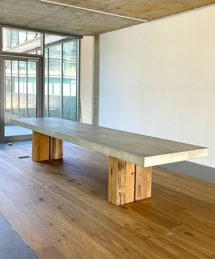 Betontisch mit Beinen aus Stammholz